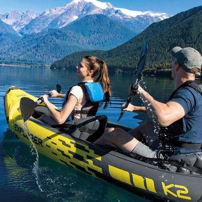 Pareja remando el INTEX Explorer K2 en un lago de montaña